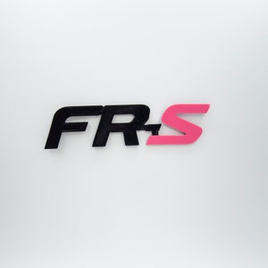 Peut inclure: Logo "FR-S" noir et rose. Le "S" est rose et le "FR" est noir.