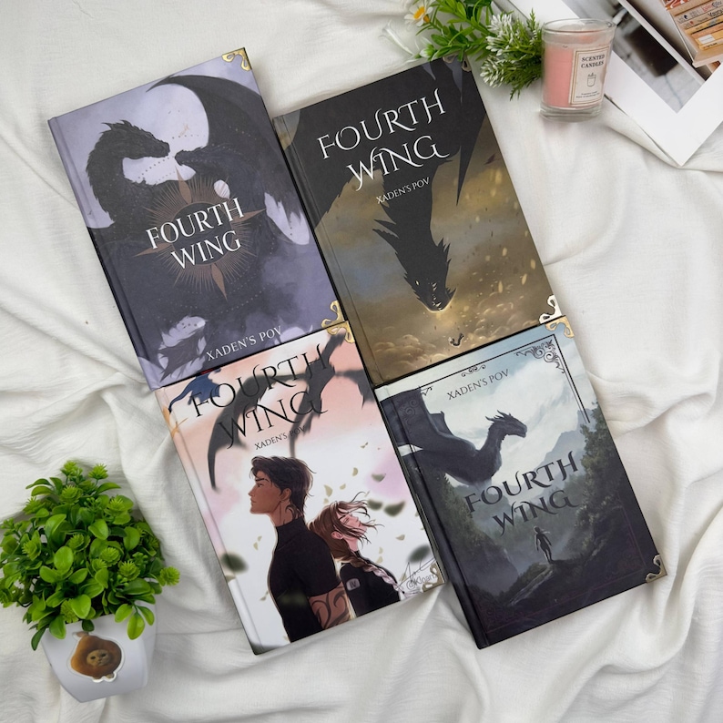 May include: Four copies of the book "Fourth Wing" are displayed, each with a unique cover design. The covers feature illustrations of dragons, figures, and landscapes, with the title prominently displayed. The text "Xaden's POV" is also visible.