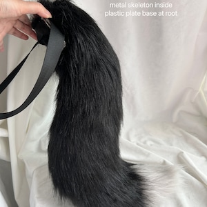 May include: Black and grey faux fur tail with a white tip. The tail is 60 inches long and has a buckle belt. It has a metal skeleton inside and a plastic plate base at the root.