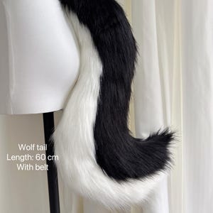 May include: Black and white wolf tail with a white tip. The tail is attached to a black belt. Wolf tail, Length: 60 cm, With belt.