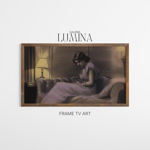 May include: A framed artwork featuring a woman in a lavender dress seated on a sofa, reading. The artwork has a vintage aesthetic, with soft lighting and a warm color palette. The frame is a dark wood color. The text "GALERIA LUMINA" is at the top.