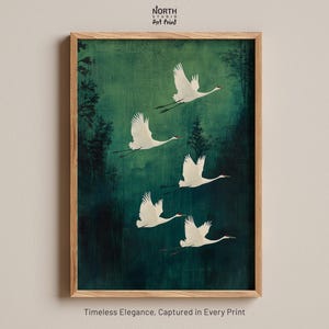 May include: A framed art print featuring five white cranes in flight against a deep green, textured background. The text North Studio Art Print appears at the top, and the text Timeless Elegance, Captured in Every Print appears at the bottom.