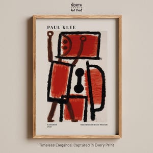 Può includere: Una stampa d'arte incorniciata che presenta l'opera Locksmith del 1940 di Paul Klee. La composizione astratta mostra audaci contorni neri e forme rosse strutturate su uno sfondo color crema. Il testo riporta Paul Klee, Locksmith 1940 e Kunstmuseum Basel Museum.