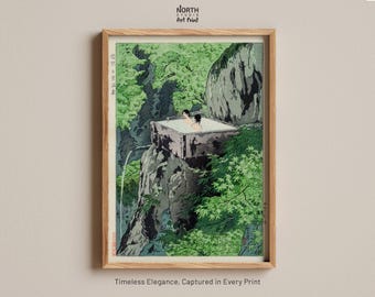 May include: A framed art print featuring a Japanese woodblock style illustration of two figures in a square outdoor hot spring bath perched on a rocky cliffside surrounded by lush green trees and foliage, with Japanese calligraphy text visible.