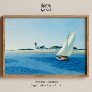 Könnte beinhalten: Ein gerahmter Kunstdruck mit dem Titel North Studio Art Print, der ein Gemälde eines weißen Segelboots auf blauem Wasser mit einem Leuchtturm und Sanddünen im Hintergrund zeigt. Der Text Timeless Elegance, Captured in Every Print steht unter dem Rahmen.