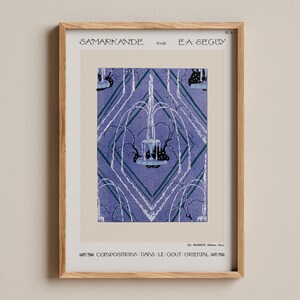 Könnte beinhalten: Gerahmter Vintage-Kunstdruck mit dem Titel "Samarkande" von E.A. Seguy. Das Kunstwerk zeigt ein stilisiertes Springbrunnen-Design in Blau- und Weißtönen auf cremefarbenem Hintergrund. Der Druck befindet sich in einem hellbraunen Holzrahmen.