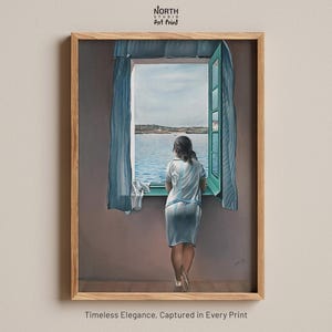 Peut inclure: Impression d'art d'une femme regardant par une fenêtre ouverte sur un paysage marin. L'œuvre présente une femme en robe blanche, des rideaux bleus et un cadre en bois. Le texte "North Studio Art Print" est en haut. Le texte "Timeless Elegance, Captured in Every Print" est en bas.
