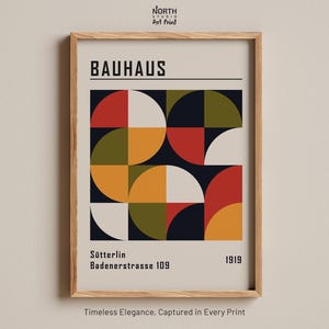 May include: A framed art print featuring the text BAUHAUS at the top and Sütterlin Badenerstrasse 109 1919 at the bottom. The central graphic consists of a grid of circles and semicircles in red, white, yellow, olive green, and dark blue colors.