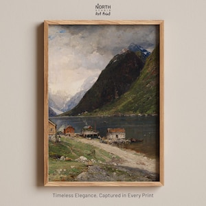 May include: A framed art print featuring a landscape painting of a fjord with steep green mountains, a dark body of water, and small wooden cabins along the shoreline under a cloudy sky. The text North Studio Art Print appears at the top.