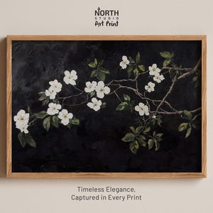 May include: A framed art print featuring a branch of white flowers against a dark background. The artwork has a textured appearance and is enclosed in a light brown wooden frame. The text "North Studio Art Print" is at the top.