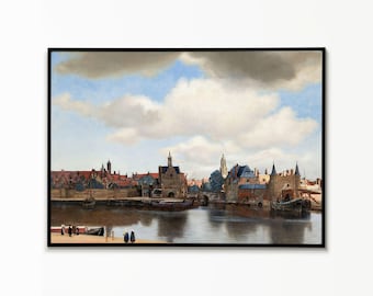 May include: A framed oil painting depicting a 17th-century Dutch cityscape with a harbour, stone buildings, and red-tiled roofs. The scene features a calm river, several small boats, and figures on the shore under a vast, cloudy blue sky.