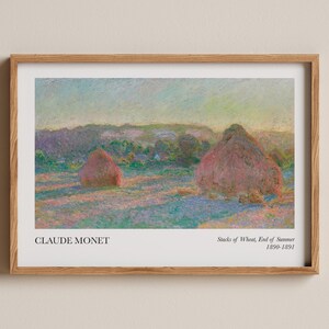 Może przedstawiać: Oprawiony wydruk "Stosy pszenicy, koniec lata 1890-1891" Claude'a Moneta. Dzieło przedstawia dwa stogi siana na polu, oddane w pastelowych odcieniach różu, błękitu i zieleni, pod miękkim, kolorowym niebem. Wydruk jest w drewnianej ramie.