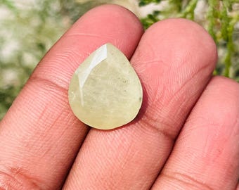 May include: A teardrop-shaped, faceted, light yellow gemstone.