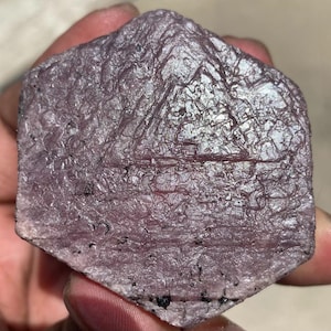 Peut inclure: Une pierre précieuse hexagonale, brute, de couleur violette avec une surface striée. La pierre précieuse a une finition naturelle non polie.