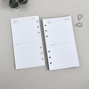 May include: Two white planner refill pages with black text and six punched holes along the side. The left page shows January 2027, Thursday 7 and Friday 8. The right page shows January 2027, Saturday 9 and Sunday 10. Two silver metal paper clips are included.