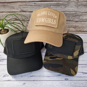 May include: Three trucker hats with black mesh backs. One hat is tan with a patch that says "Long Live Cowgirls" in white. One hat is black with a black patch. One hat is camouflage with a black patch.