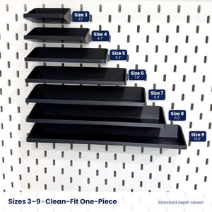 May include: A set of seven black rectangular shelves mounted on a white pegboard. The shelves are arranged in increasing order of length, labeled Size 3 through Size 9, with corresponding measurements from 3.1 inches to 12.6 inches displayed.