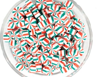 Puede incluir: Un bol lleno de cuentas de madera con estampado de bastón de caramelo rojo y verde. Las cuentas son de madera y tienen un fondo blanco con rayas rojas y verdes.