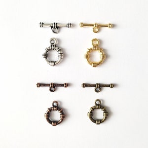 May include: Four sets of silver, gold, and bronze toggle clasps. Each set includes a bar and a ring with a decorative twisted wire design.