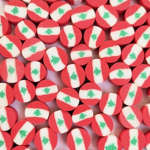 May include: A collection of red, white, and green round beads with the flag of Lebanon printed on them.