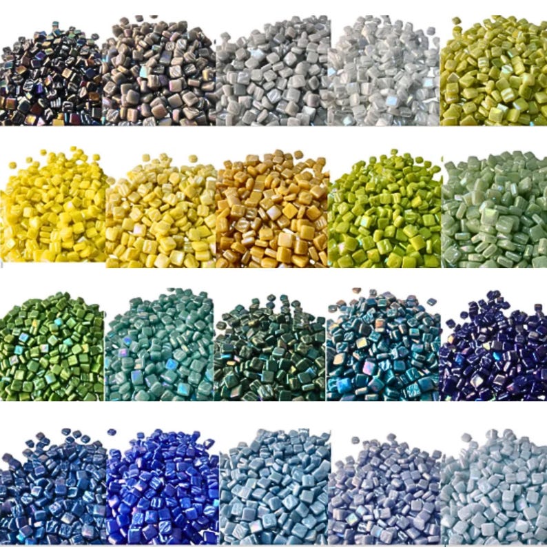 May include: A collection of small, square glass mosaic tiles in various colors. The tiles range from dark blues and greens to lighter shades of yellow, green, and gray. The tiles are arranged in rows, showcasing the variety of colors available.