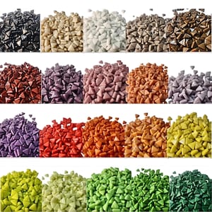Op de afbeelding: Een verzameling kleine, driehoekige mozaïektegels in verschillende kleuren, waaronder zwart, beige, wit, bruin, rood, paars, oranje en groen. De tegels zijn in rijen gerangschikt en tonen het diverse kleurenpalet dat beschikbaar is voor knutsel- en designprojecten.