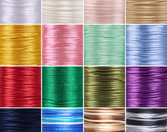 Puede incluir: Una colección de 16 carretes de cordón de algodón encerado en varios colores, incluyendo blanco, rosa, verde, azul, rojo, morado, marrón y negro. Los cordones están dispuestos en un patrón de cuadrícula.