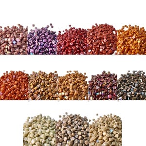 May include: A collection of small, square mosaic tiles in various colors, including shades of brown, purple, red, and gold. The tiles are arranged in rows, showcasing the range of hues and textures available for crafting projects.