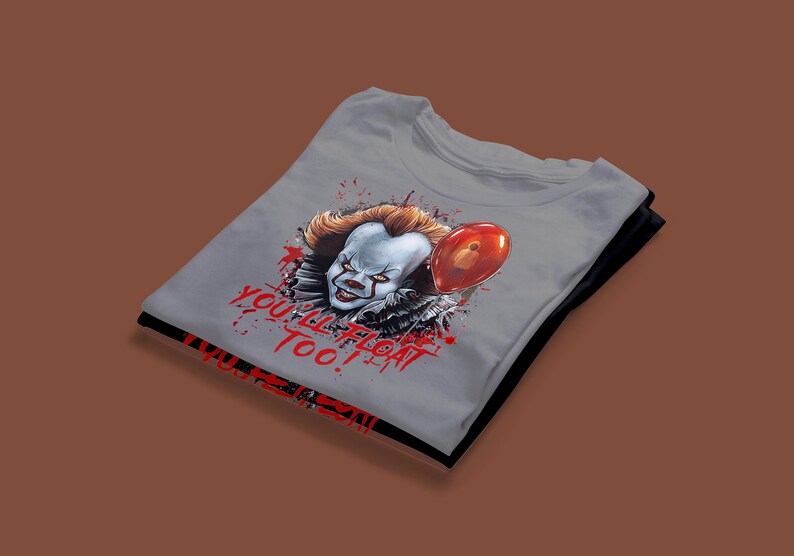May include: A gray t-shirt with a graphic of Pennywise the clown from the movie "IT". The graphic shows Pennywise holding a red balloon with the text "You'll Float Too!" in red.