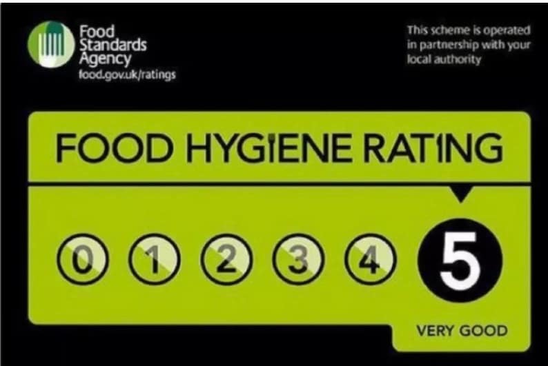May include: A green and black food hygiene rating sticker with a white number 5 in a black circle. The text "VERY GOOD" is below the number. The sticker is from the Food Standards Agency.