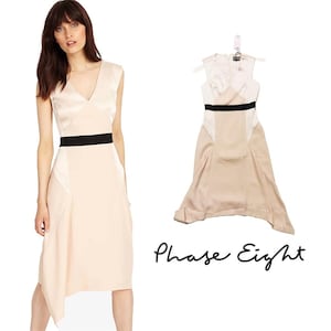 May include: A blush pink and white dress with a black belt. The dress has a satin bodice and a flowing skirt. The dress is from the brand Phase Eight.