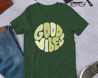 May include: A dark green t-shirt with a yellow and light green circle graphic that says "GOOD VIBES" in a retro font.