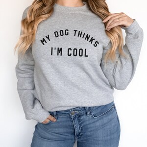 May include: A gray sweatshirt with the text "My dog thinks I'm cool" printed on the front.