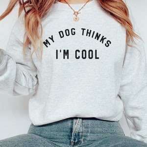 May include: A gray sweatshirt with the text "My dog thinks I'm cool" printed on the front.