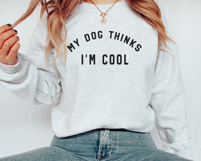 May include: A gray sweatshirt with the text "My dog thinks I'm cool" printed on the front.