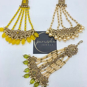 May include: Three gold-toned hair accessories with dangling beads. The top accessory has yellow beads, the middle accessory has white beads, and the bottom accessory has green beads.