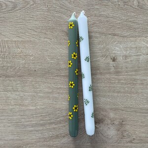 Bloemen geschilderde kaarsen. Dinerkaarsen. Handbeschilderde kaarsen. Groene kaarsen met gele zonnebloemen en witte kaarsen met groene blaadjes.