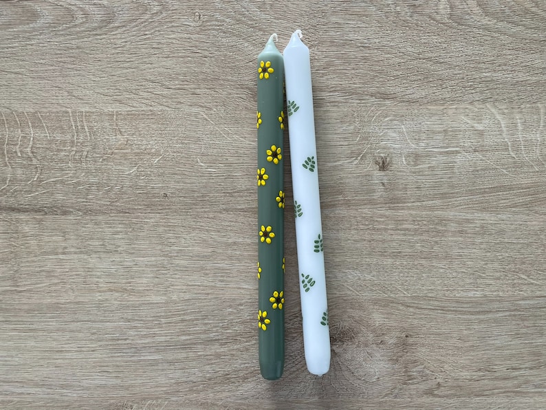 Bloemen geschilderde kaarsen. Dinerkaarsen. Handbeschilderde kaarsen. Groene kaarsen met gele zonnebloemen en witte kaarsen met groene blaadjes.