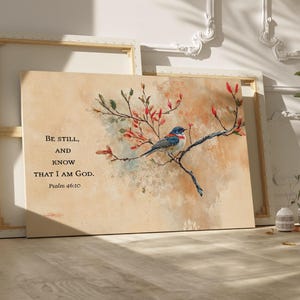 May include: A watercolor painting of a bluebird perched on a branch of a tree with red blossoms. The painting has a beige background and includes the text "Be still, and know that I am God, Psalm 46:10".