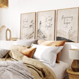 May include: Three framed wall art prints featuring black ink illustrations on a beige background. The first print displays a tree and the text The Lord is my Peace. The second shows a lighthouse and the text The Lord is my light. The third shows a plant and the text Rejoicing in hope Romans 12:12.