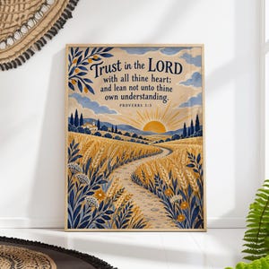 Op de afbeelding: Een rechthoekige wandkunstprint met een goudkleurig tarweveld onder een zonsopgang, met een kronkelend pad dat naar een klein huis leidt. De tekst luidt: Trust in the LORD with all thine heart; and lean not unto thine own understanding. PROVERBS 3:5.