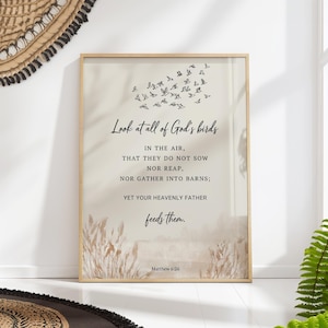 May include: A framed art print with the text "Look at all of God's birds" and a flock of birds illustration. The print includes the Bible verse Matthew 6:26. The artwork has a beige background and a wooden frame, suitable for home decor.