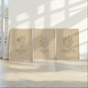 May include: Three framed botanical art prints with inspirational quotes. Each print features a different floral illustration in a minimalist style. The quotes are: "The fear of the LORD is the beginning of wisdom," "Trust in the LORD with all your heart," and "Commit your word to the LORD."