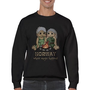 Könnte beinhalten: Schwarzer Pullover mit einem Motiv von zwei Trollen, die an einem Lagerfeuer sitzen. Der Text "NORWAY where magic happens" ist unter dem Motiv gedruckt.