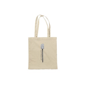 May include: A beige canvas tote bag with a black and white illustration of a spatula and the text "allikepottt".