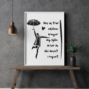 Puede incluir: Una ilustración en blanco y negro de una persona bailando bajo la lluvia con un paraguas. El texto dice "Si crees que el sol te trae felicidad, entonces no has bailado bajo la lluvia."
