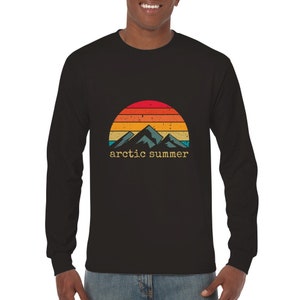 May include: Black long-sleeved t-shirt featuring a retro-style graphic of mountains and a sunset with the text "arctic summer".