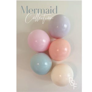 May include: A set of five pastel colored balloons in shades of pink, blue, and cream. The balloons are arranged in a circle on a white background. The text "Mermaid Collection" is written above the balloons.