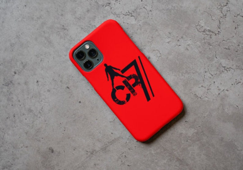 May include: Red phone case with a black silhouette of a soccer player and the text "CR7" printed on it.