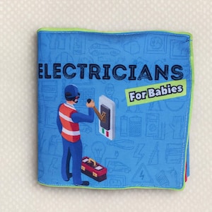 Puede incluir: Un libro de tela azul titulado "ELECTRICIANS For Babies" presenta una ilustración de un electricista trabajando en un interruptor. El libro tiene un borde verde y una caja de herramientas roja. El fondo está lleno de iconos con temática eléctrica.